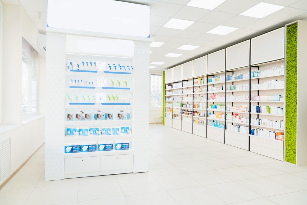 Empty spacious modern new white drugstore pharmacy chemist`s store with shelves full of medicines, pills, vitamins, painkillers, antibiotics without visitors